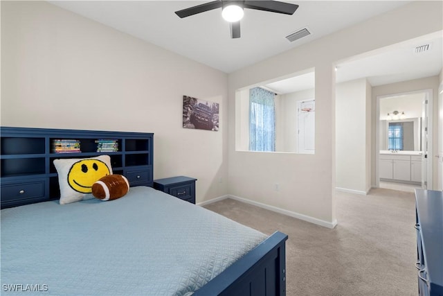 bedroom featuring ceiling fan, ensuite bathroom, and light carpet