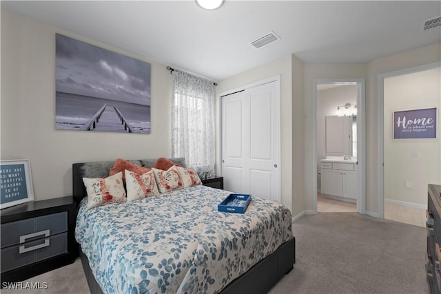 carpeted bedroom featuring ensuite bathroom, a closet, and sink