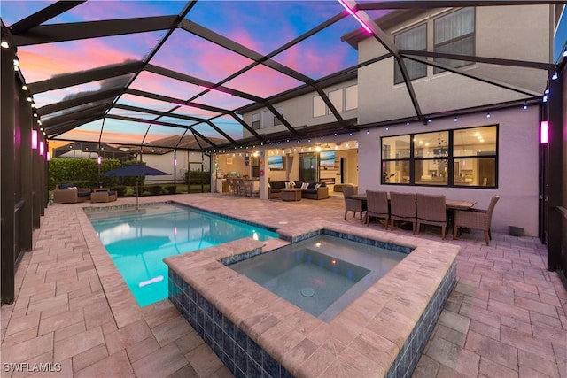 pool at dusk featuring an outdoor living space, a patio area, a lanai, and an in ground hot tub