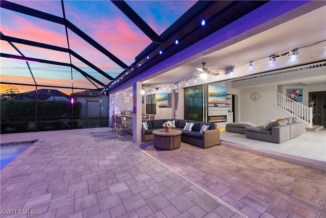 patio terrace at dusk featuring an outdoor hangout area and a lanai