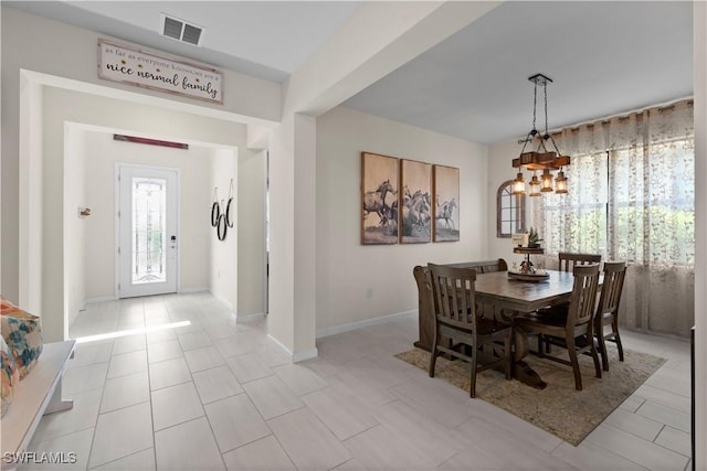 tiled dining space with an inviting chandelier