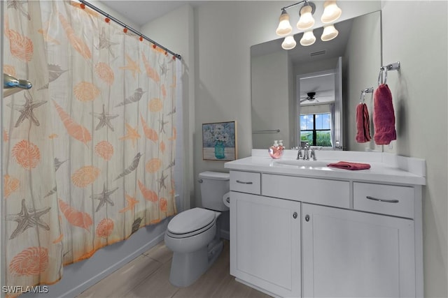 full bathroom featuring ceiling fan, shower / tub combo with curtain, vanity, and toilet