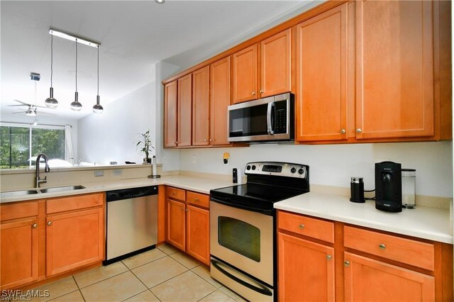 kitchen featuring pendant lighting, light tile patterned floors, stainless steel appliances, sink, and ceiling fan