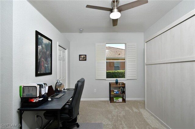 carpeted office featuring a textured ceiling and ceiling fan