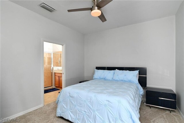 carpeted bedroom with ensuite bathroom and ceiling fan