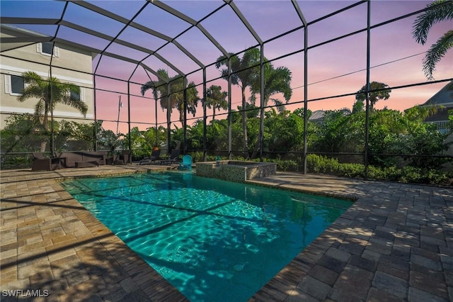 view of swimming pool featuring a lanai, a patio area, and a pool with connected hot tub