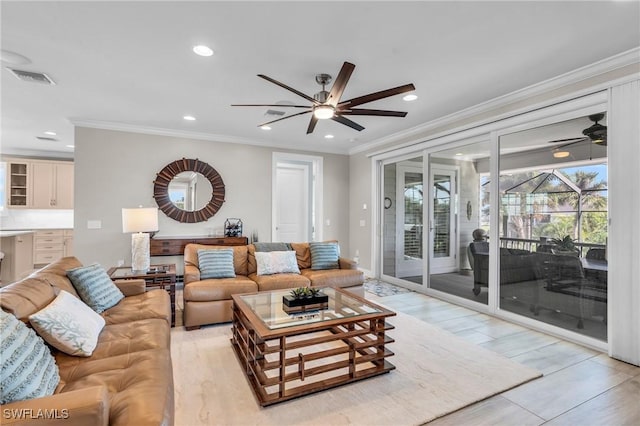 living area with light wood-type flooring, ceiling fan, ornamental molding, and recessed lighting