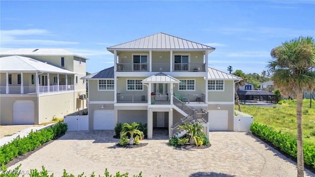 coastal inspired home with a garage, a standing seam roof, and metal roof