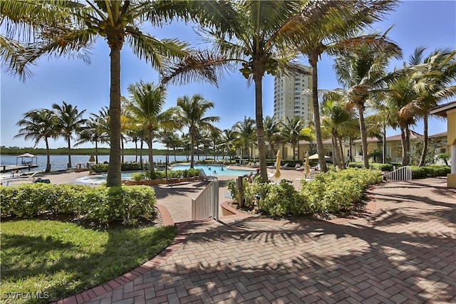 view of community featuring a patio area, a swimming pool, and a water view