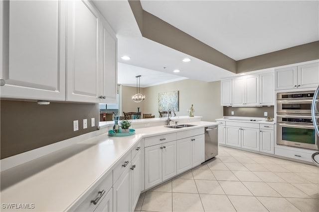 kitchen with sink, white cabinetry, decorative light fixtures, and stainless steel appliances