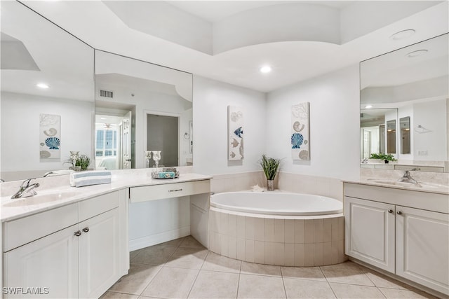 bathroom with vanity, a relaxing tiled tub, and tile patterned floors