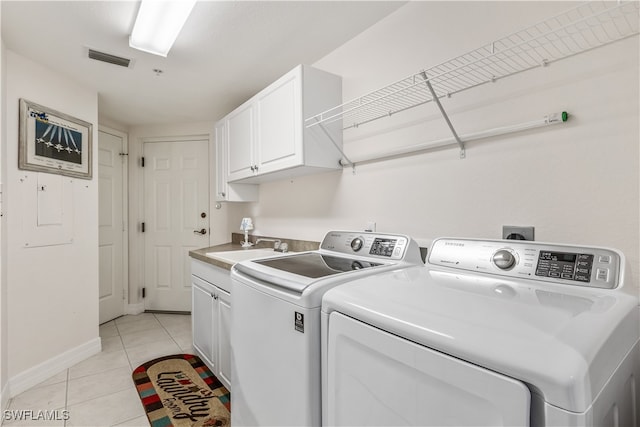 washroom featuring cabinets, sink, separate washer and dryer, and light tile patterned floors