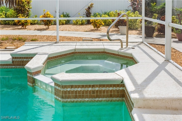 view of swimming pool featuring an in ground hot tub