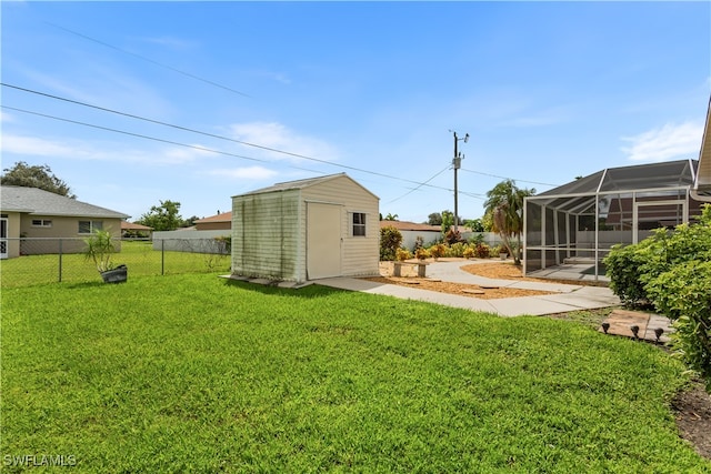 view of yard with glass enclosure, a patio area, and a shed