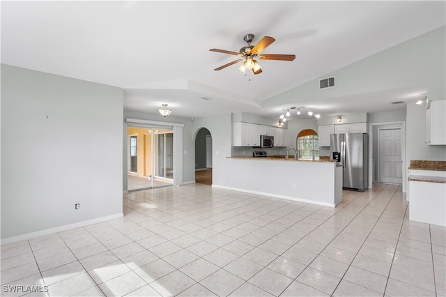 unfurnished living room featuring lofted ceiling, light tile patterned flooring, sink, and ceiling fan