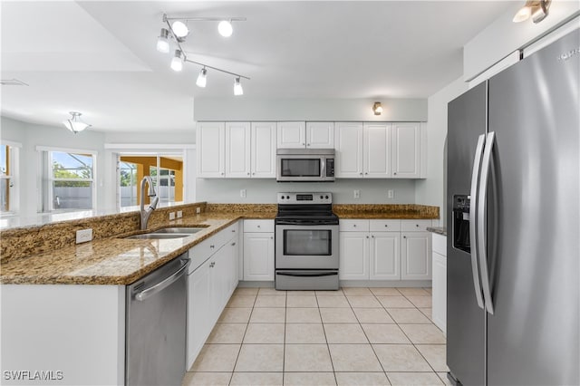 kitchen featuring appliances with stainless steel finishes, stone counters, sink, and white cabinets