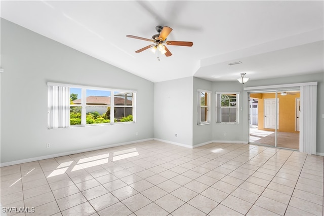 spare room with vaulted ceiling, a wealth of natural light, light tile patterned floors, and ceiling fan