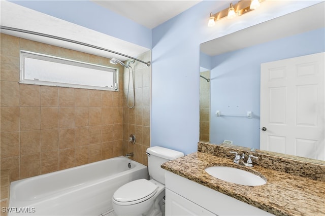 full bathroom featuring tiled shower / bath, toilet, and vanity