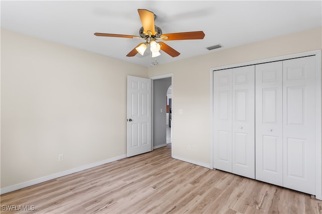 unfurnished bedroom with ceiling fan, a closet, and light wood-type flooring