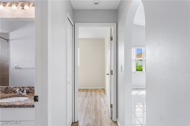 hall featuring light wood-type flooring and sink