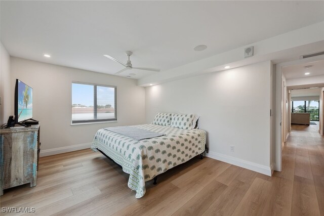 bedroom with ceiling fan, light wood-type flooring, and multiple windows