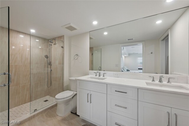 bathroom with toilet, an enclosed shower, and vanity