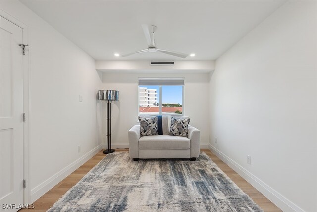 living area with ceiling fan and wood-type flooring