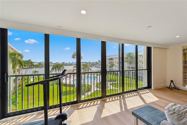 sunroom featuring a water view