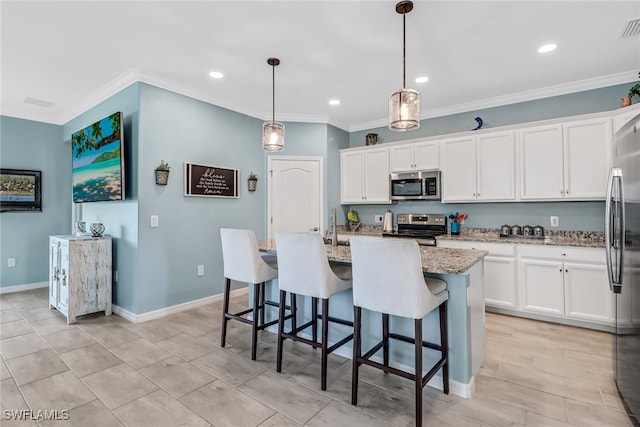 kitchen with a kitchen island with sink, white cabinets, stainless steel appliances, and decorative light fixtures