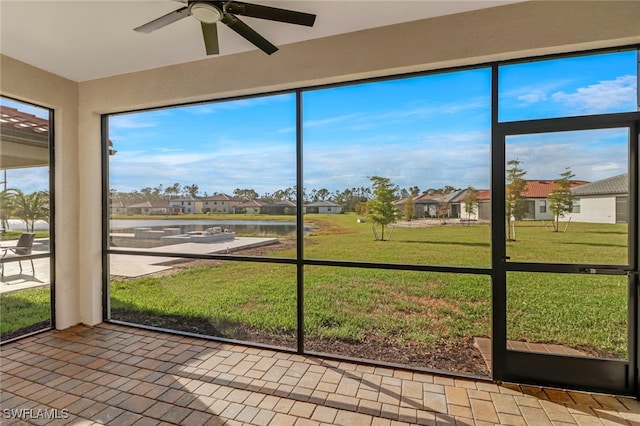 unfurnished sunroom with ceiling fan