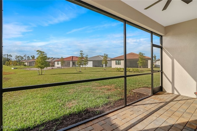 unfurnished sunroom with ceiling fan