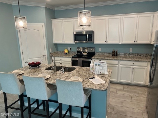 kitchen with sink, an island with sink, hanging light fixtures, and appliances with stainless steel finishes