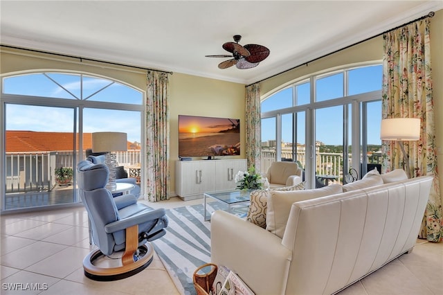 living room with crown molding, plenty of natural light, light tile patterned floors, and ceiling fan