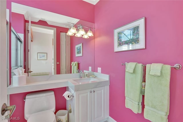 bathroom featuring vanity, crown molding, and toilet