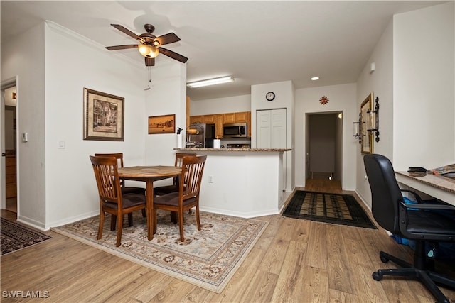 dining space featuring light wood-type flooring, ornamental molding, and ceiling fan