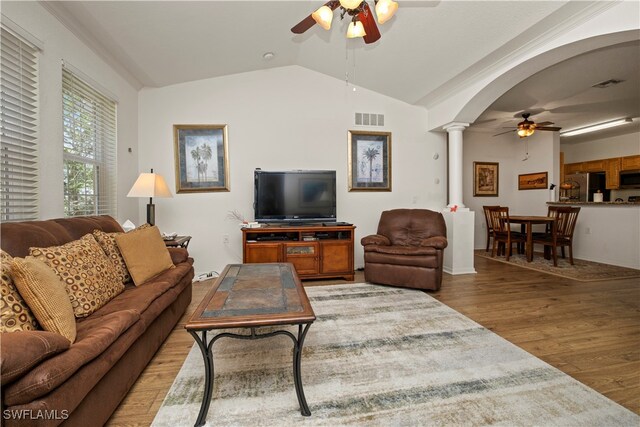 living room with ceiling fan, hardwood / wood-style flooring, lofted ceiling, and ornate columns