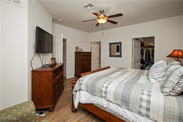 bedroom with ceiling fan, a closet, hardwood / wood-style floors, and a spacious closet