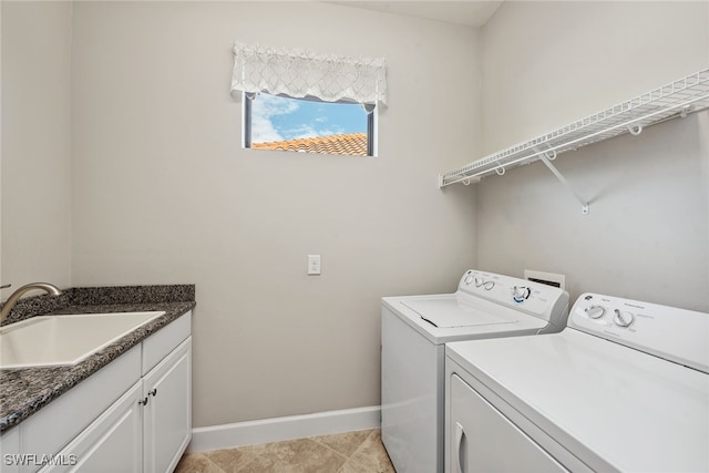 clothes washing area with washing machine and clothes dryer, cabinets, sink, and light tile patterned floors