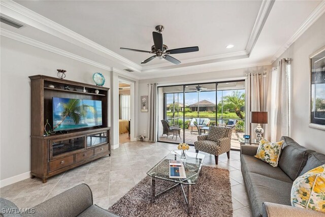 tiled living room with crown molding, ceiling fan, and a tray ceiling