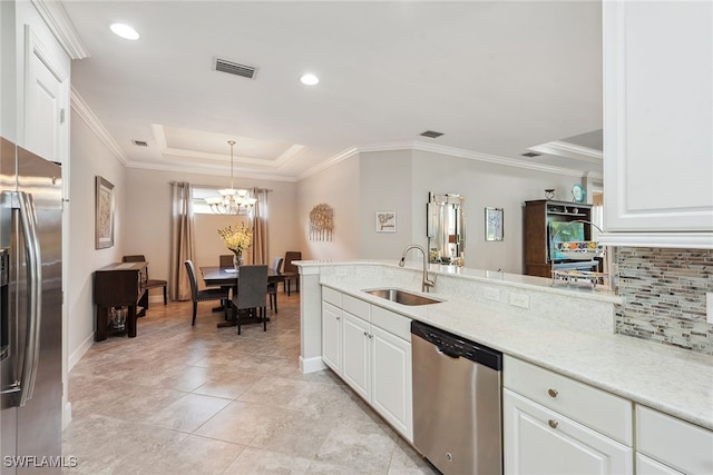 kitchen featuring hanging light fixtures, sink, appliances with stainless steel finishes, and white cabinetry