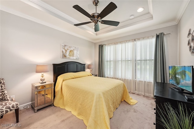 bedroom featuring a tray ceiling, crown molding, ceiling fan, and carpet floors