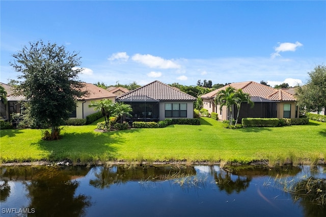 rear view of house featuring a yard and a water view