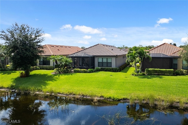 back of house featuring a yard and a water view