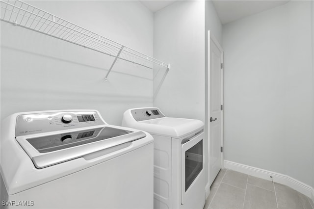 laundry room featuring independent washer and dryer and light tile patterned floors