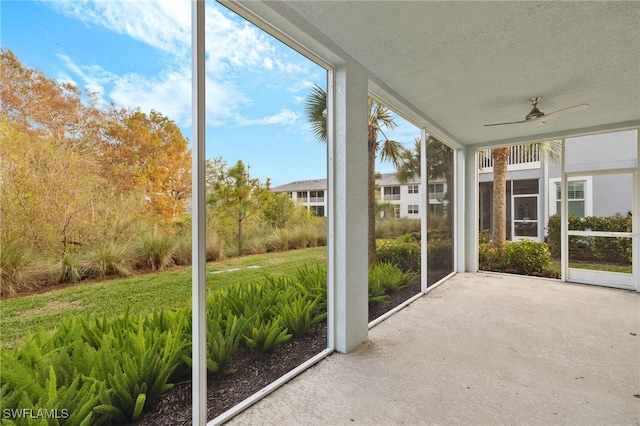 unfurnished sunroom featuring ceiling fan