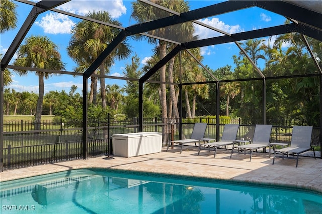 view of swimming pool with glass enclosure and a patio area