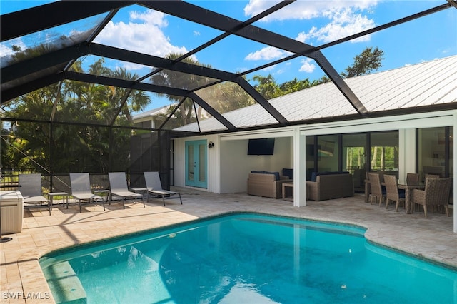 view of pool with a lanai, an outdoor hangout area, a patio area, and french doors