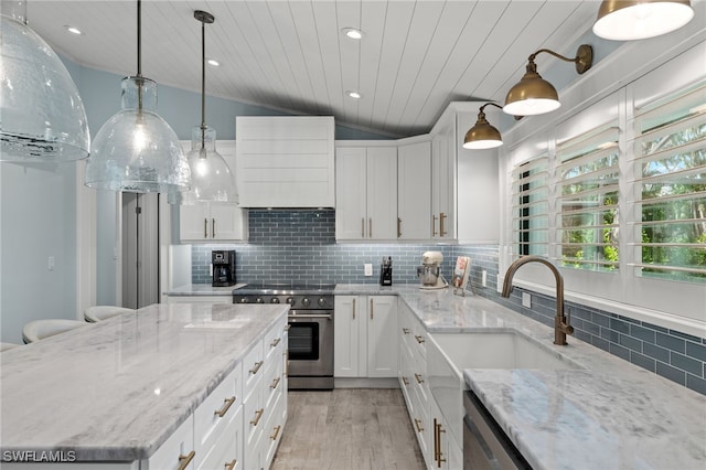 kitchen featuring appliances with stainless steel finishes, backsplash, lofted ceiling, and white cabinets