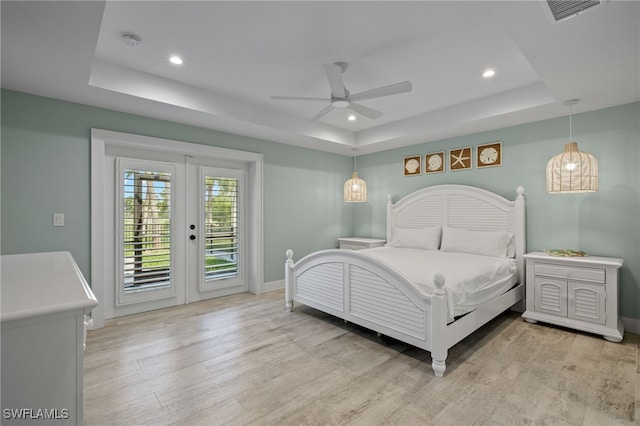 bedroom with access to outside, a raised ceiling, ceiling fan, and light hardwood / wood-style flooring