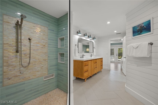 bathroom featuring vanity, tile patterned flooring, and tiled shower